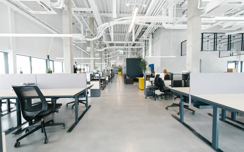 Modernes Großraumbüro mit sichtbarer Gebäudetechnik an der Decke