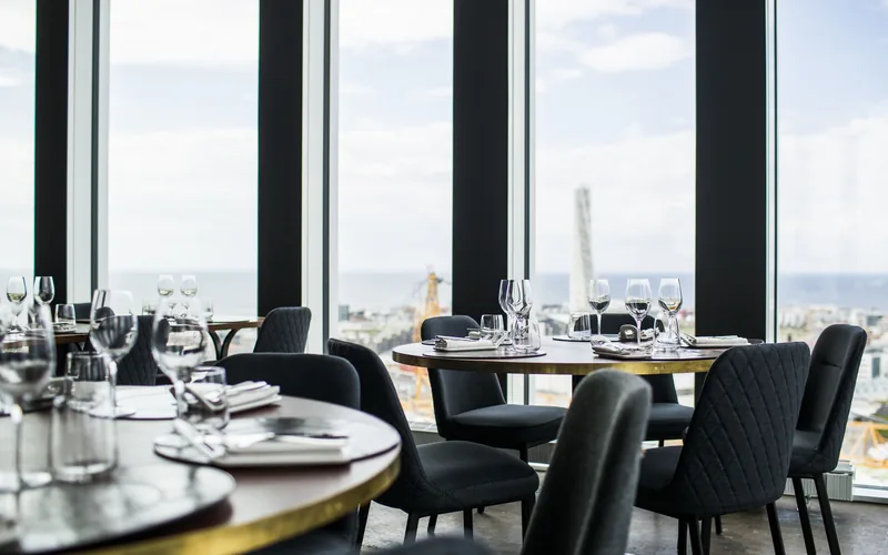 Eingedeckte Tische in einem Restaurant mit Panoramafenstern