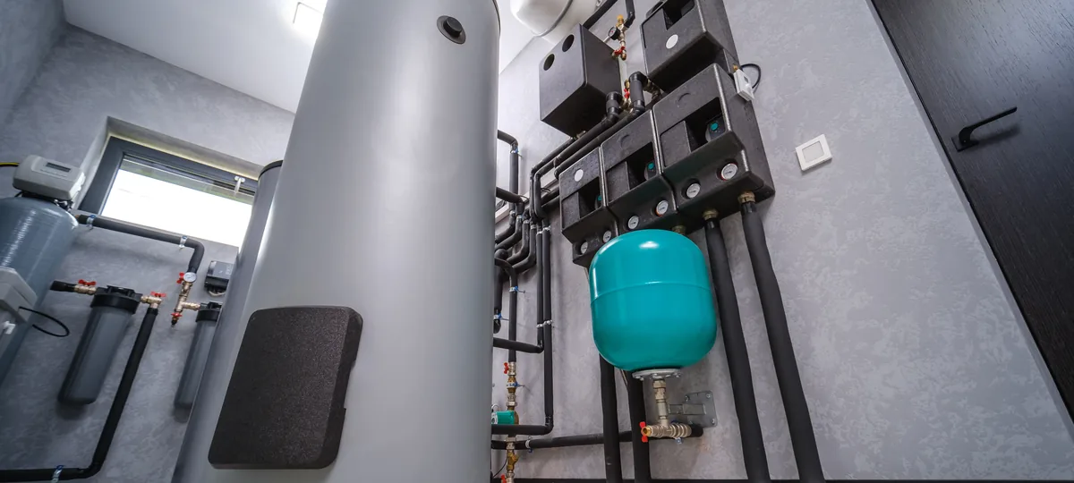Technikraum mit Pufferspeicher, Verrohrung und Regelung einer Wärmepumpenanlage